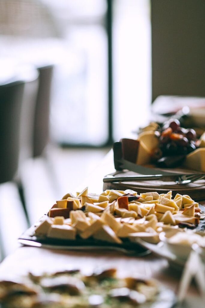 Delicious appetizers served on plates on wooden banquet table in cafeteria in light day